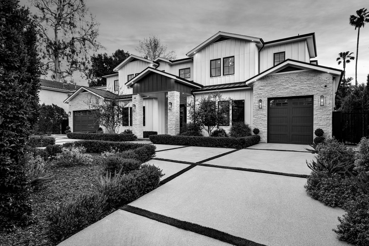 Contemporary farmhouse with stone accents and landscaped driveway