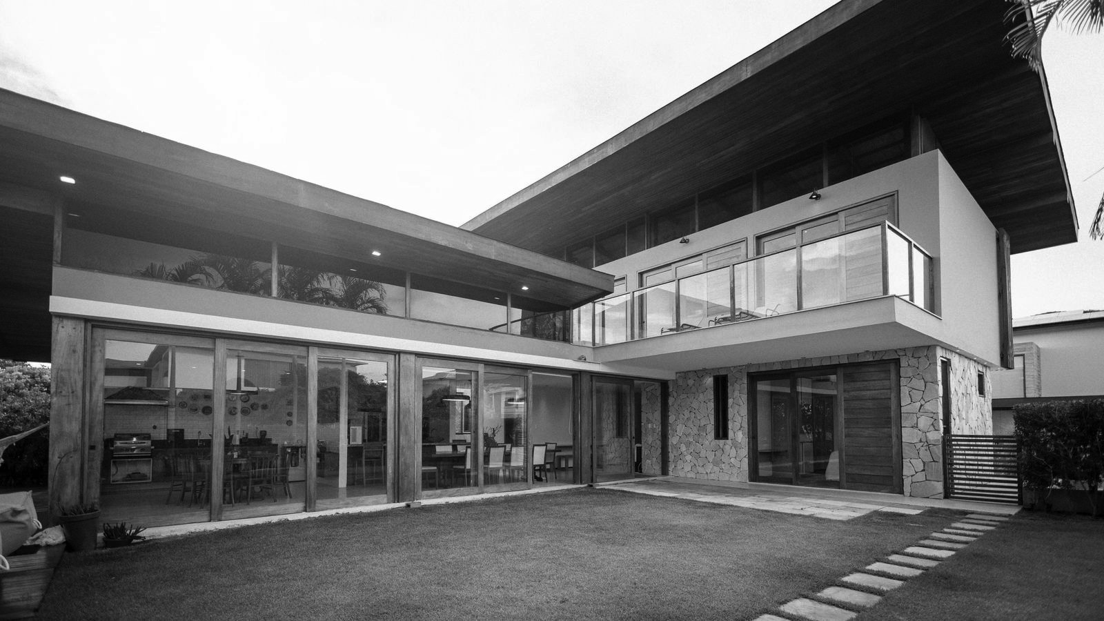 Modern glass and wood investment property with a courtyard lawn, the kind of high-value rental Pinnacle Funding Network finances